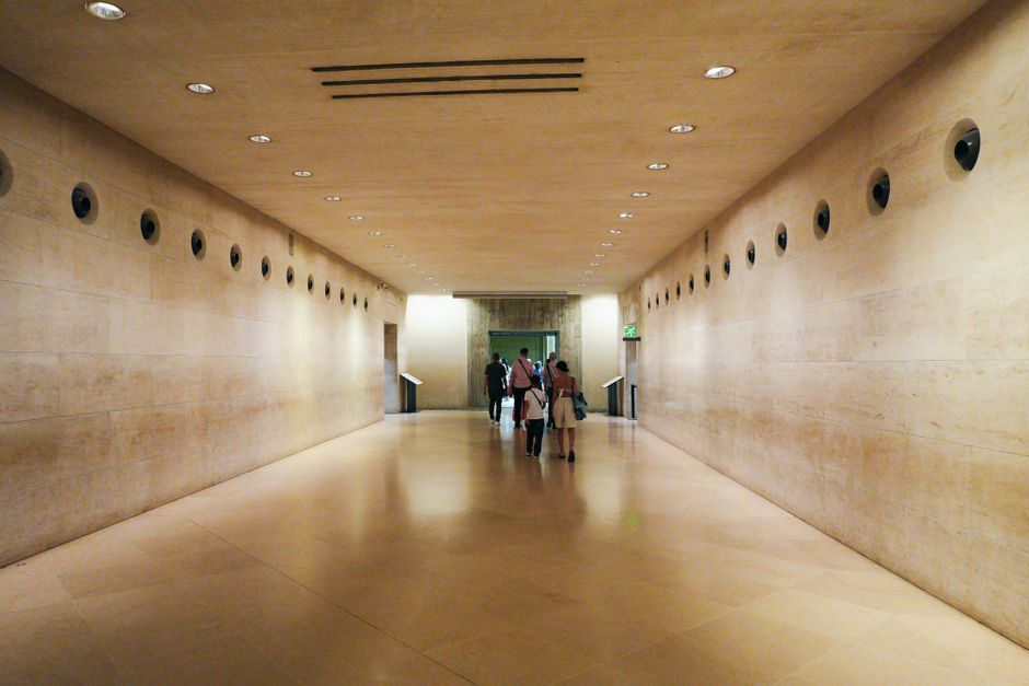 Visitors exploring a modern corridor inside the Louvre Museum, Paris.