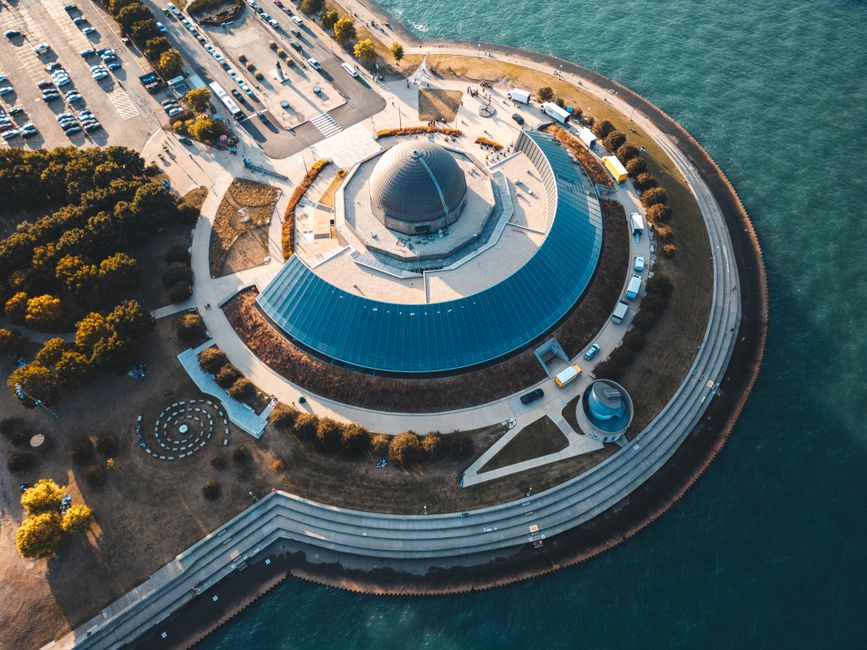 A stunning aerial view of Adler Planetarium Chicago surrounded by water and green landscapes.